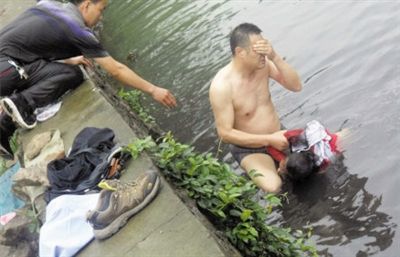 網(wǎng)友貼出民警張光聰一出河水就睜不開眼，用手抹去臉上臟水的照片。
