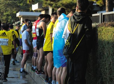 2013年10月20日，北京馬拉松比賽，由于廁位有限，一些選手在綠化帶“就地解決”。圖/IC