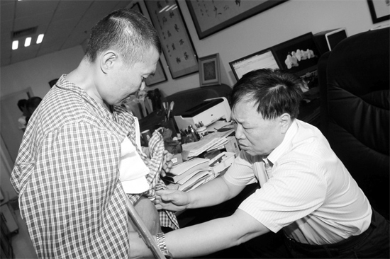 昨天，陜西西安第四軍醫(yī)大學(xué)唐都醫(yī)院骨腫瘤專家范清宇教授（右）在為李剛做檢查